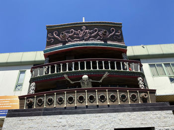 Low angle view of temple building against clear blue sky