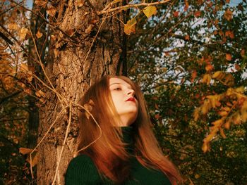 Beautiful woman by tree during autumn