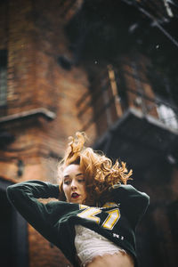 Low angle view of woman against building