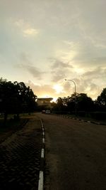 Empty road against sky at sunset