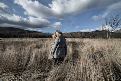 Woman standing on field against sky