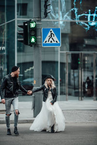 Full length of woman with umbrella on street in city