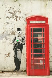 Red telephone booth on wall