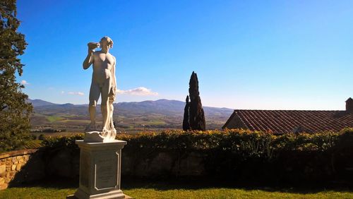 Statue on field against sky