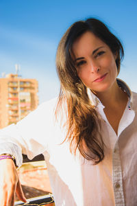 Portrait of beautiful woman standing against sky