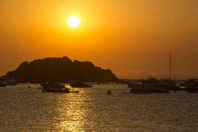 Silhouette of marina at sunset with boats and sun reflected