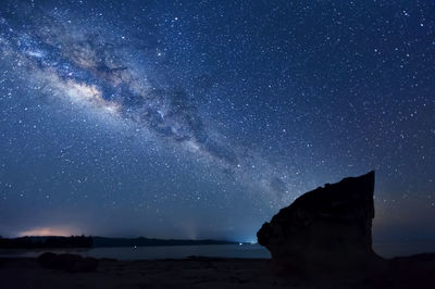 View of star field over beach at night