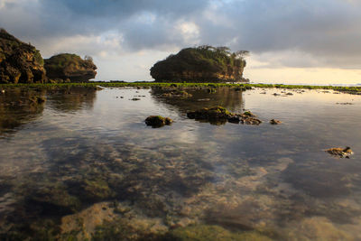 Rocks in sea against sky
