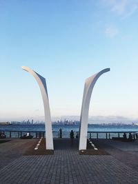 Rear view of people overlooking sea against sky