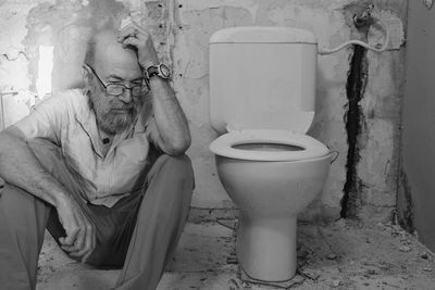 Portrait of young woman sitting in bathroom