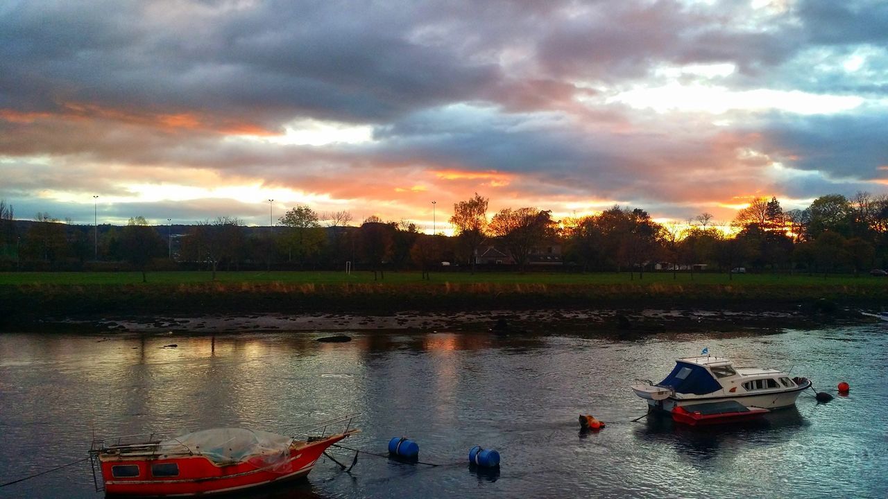 BOATS MOORED IN WATER AGAINST SKY