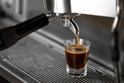 Close-up of coffee pouring in glass