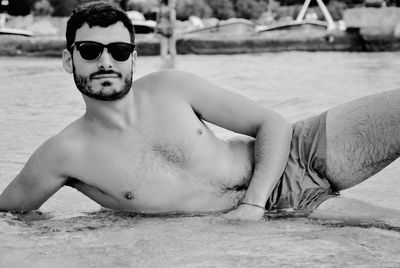 Portrait of young man sitting in swimming pool