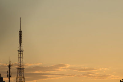 Low angle view of communications tower against sky during sunset