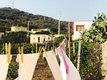 Clothes drying on clothesline by building against sky