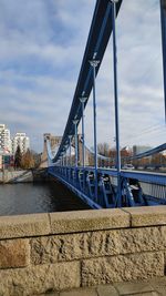 Bridge over river against sky in city