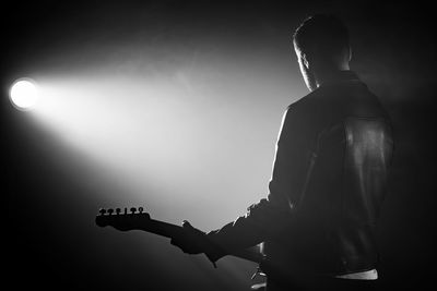 Rear view of man playing guitar