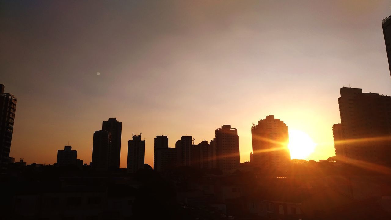 SILHOUETTE BUILDINGS AGAINST SUNSET SKY