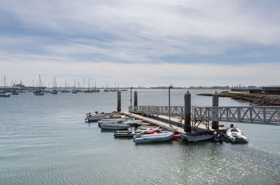 Sailboats moored on sea against sky