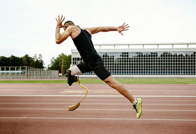 Full length of man jumping against the sky