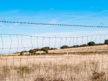 Fence on field against sky