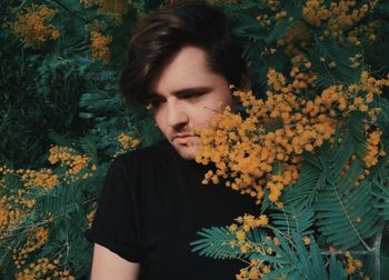 Thoughtful young man amidst branches