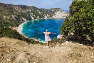 Man standing on shore by mountain