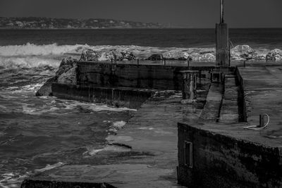 Abandoned built structure in sea against sky