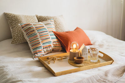 Linen pillows on a white bed with home decor. still life details in home on a bed. cozy home.