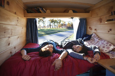 Couple relaxing on bed in camper van