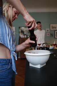 Young woman preparing food in kitchen at home