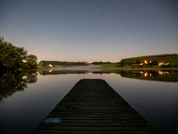 Scenic view of lake against sky at night