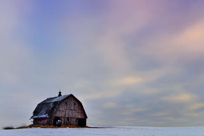 Abandoned building by sea against sky during sunset