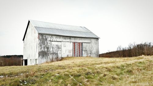 Abandoned barn on field against sky