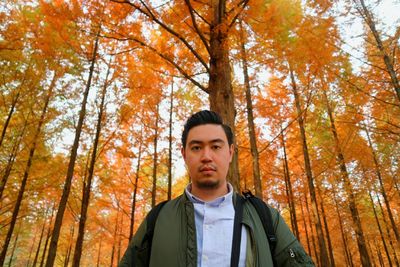 Portrait of young man in forest during autumn