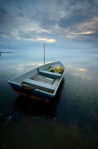 Boat moored on sea against sky