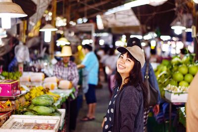 Portrait of smiling mid adult woman standing at market stall