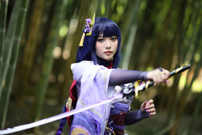 Side view of young woman holding umbrella