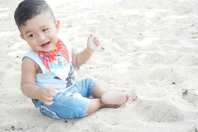 Portrait of cute boy sitting on beach