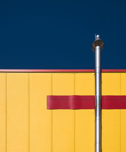 Low angle view of illuminated street light against clear blue sky