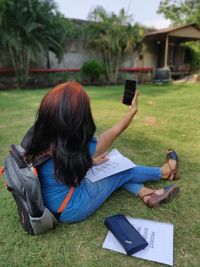 Woman using mobile phone while sitting on grass