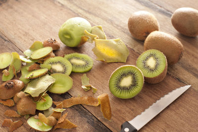 High angle view of kiwis and knife on cutting board