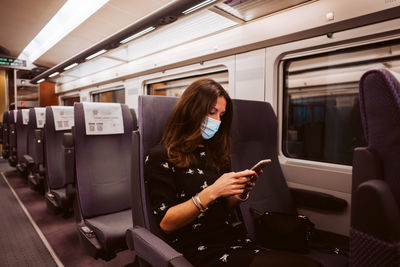 Rear view of woman traveling in train