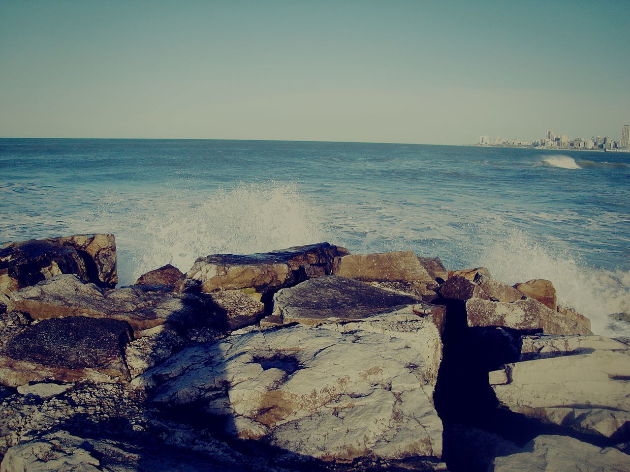 sea, water, horizon over water, rock - object, scenics, tranquil scene, beauty in nature, tranquility, nature, clear sky, wave, tourism, shore, non-urban scene, vacations, remote, sky, outdoors, seascape, coastal feature, splashing, rock formation, majestic