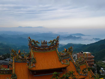 Temple by building against sky