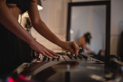 Midsection of woman playing sound mixer at home