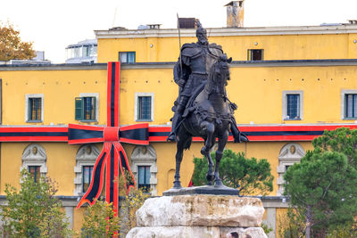 Statue against building in city