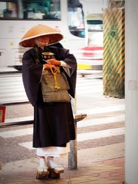 Midsection of woman with umbrella walking in city