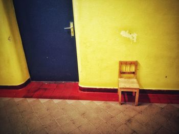 Empty chairs against wall in building