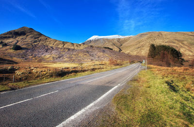 Road on mountain against blue sky